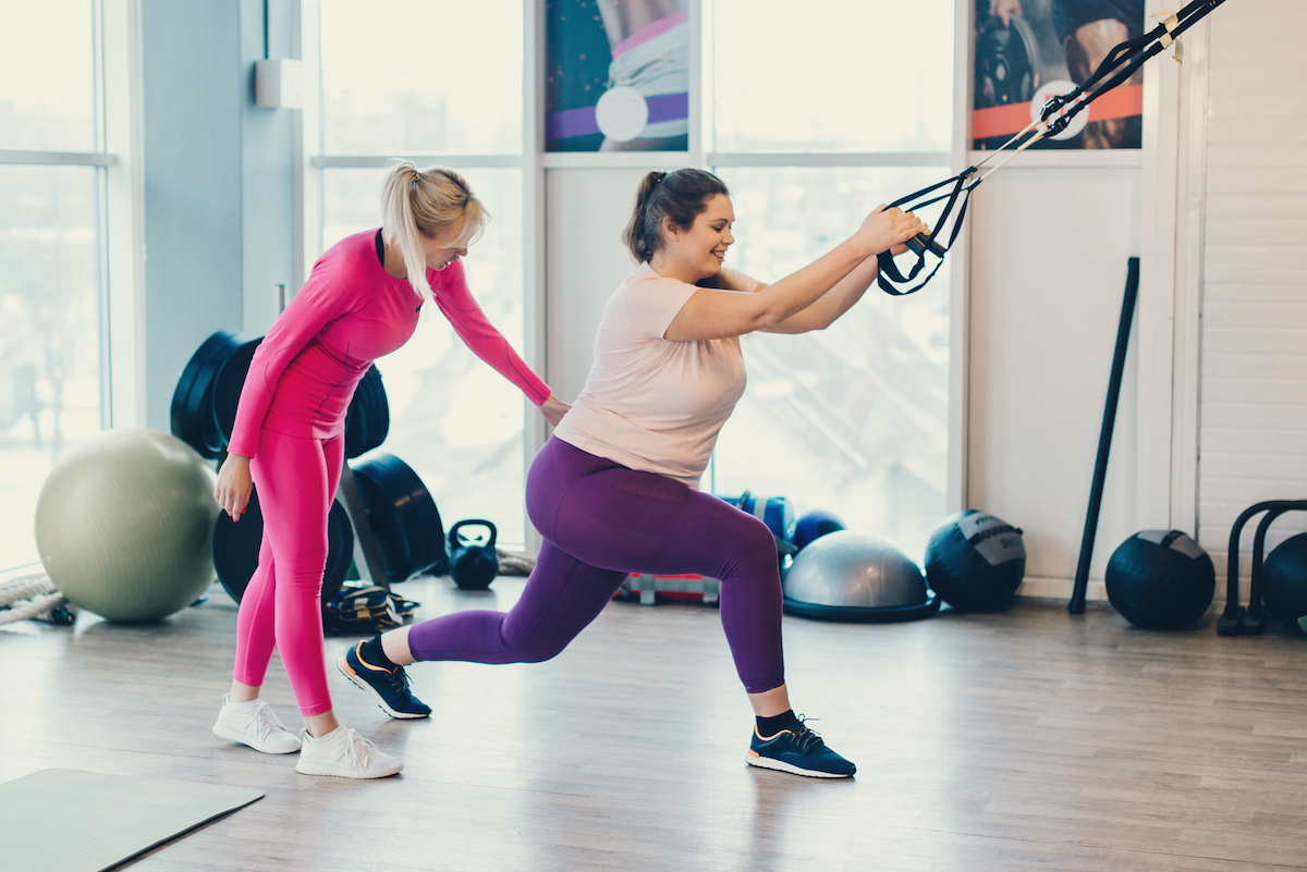 https://generationfitfl.com/wp-content/uploads/2021/04/large-boned-woman-working-out-with-TRX-bands-fitness-insturctor-supporting-hip.jpeg